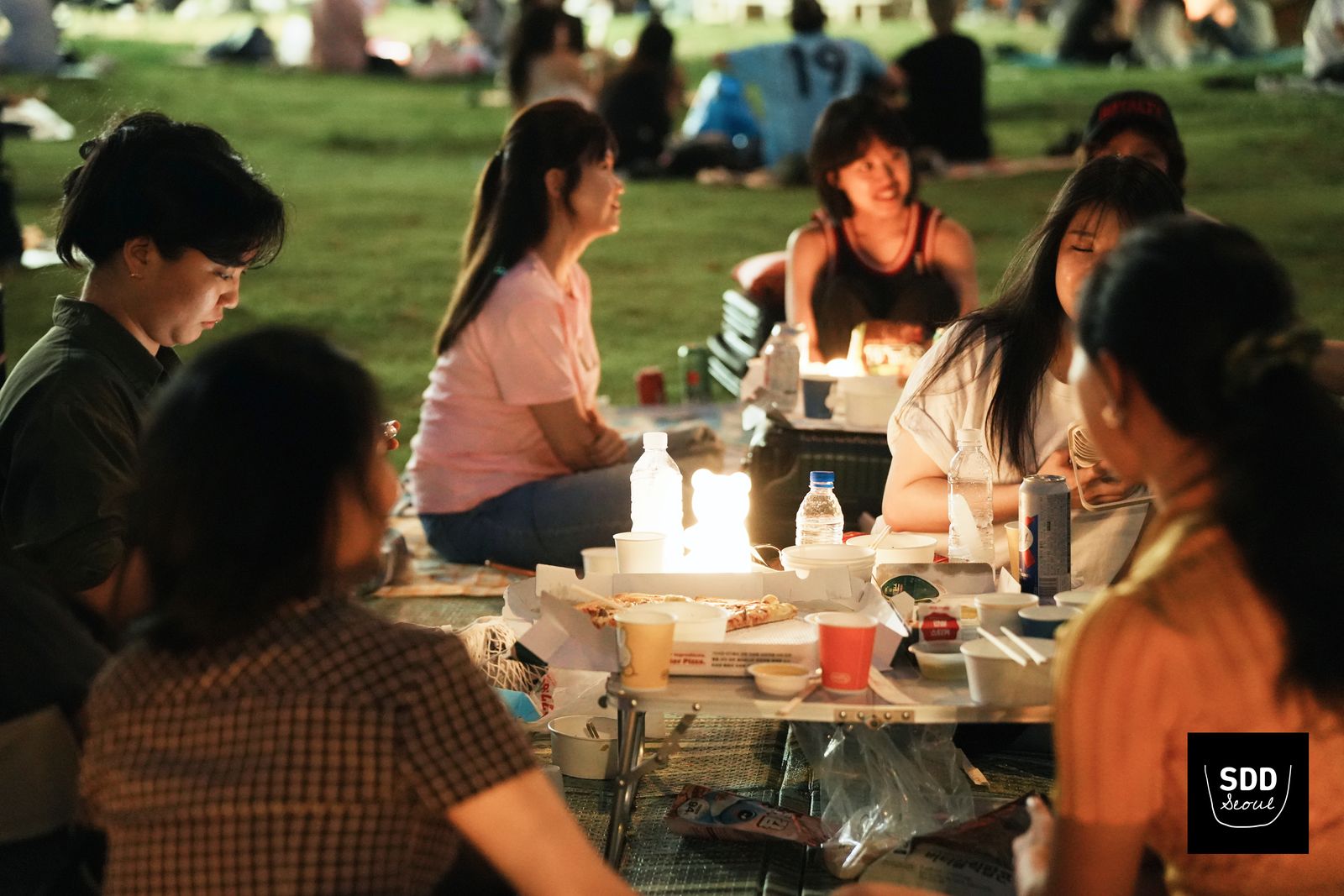밤 피크닉 테이블에 모여 앉은 참가자들