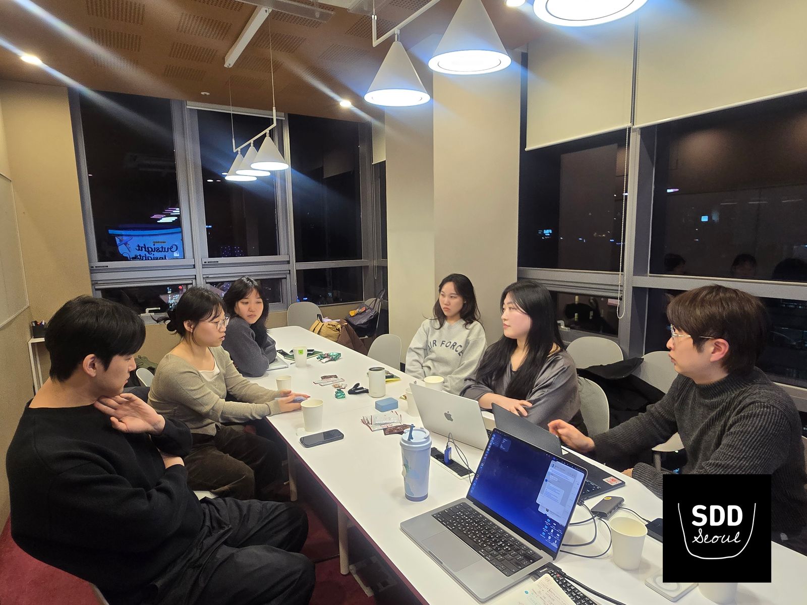 서비스디자인드링크 서울 인사이트 공유회, 긴 테이블에 둘러앉아 경험을 나누는 참가자들